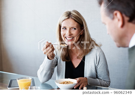 Catching up at breakfast. Shot of a mature couple eating breakfast in their kitchen. Catching up at breakfast. Shot of a mature couple eating breakfast in their kitchen. 96062349