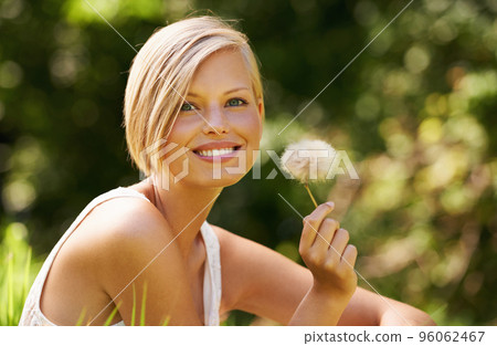 Fascinated by nature. Shot of an attractive young woman outdoors on a summer day. 96062467