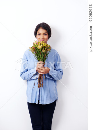 Beautiful as a bouquet. Studio shot of an attractive young ethnic woman holding a bouquet of flowers. 96062658