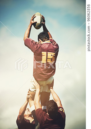 Perfectly executing a lineout. Shot of a young rugby player catching the ball during a lineout. 96062856