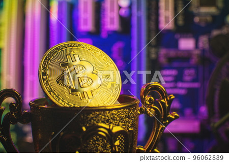 Cryptocurrency concept , Golden bitcoin on winners cup background mainboard , The future of money. Computational equipment. 96062889