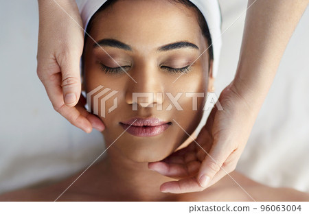 We give all our clients the special treatment. Shot of a young woman getting a facial treatment at a spa. 96063004
