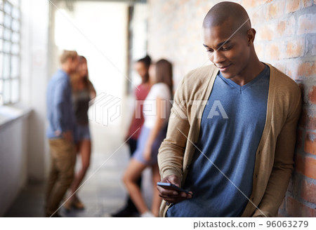 Making plans. Shot of a young man sending a text message. 96063279