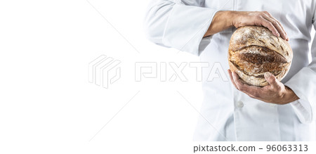 A crusty loaf of fresh bread in the baker's hands. 96063313