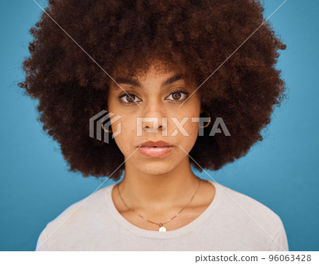 Black woman, natural hair and afro for skincare, hair care and beauty on a blue studio background. Face portrait or headshot of an African model posing for cosmetic, fashion and self care motivation Black woman, natural hair and afro for skincare, hair care and beauty on a blue studio background. Face portrait or headshot of an African model posing for cosmetic, fashion and self care motivation 96063428