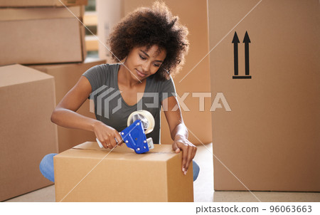 Heres to a new start. Shot of a young woman moving into her new house. Heres to a new start. Shot of a young woman moving into her new house. 96063663