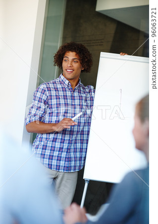 Putting his corporate strategy forward. Casual young businessman giving a presentation using a whiteboard. Putting his corporate strategy forward. Casual young businessman giving a presentation using a whiteboard. 96063721