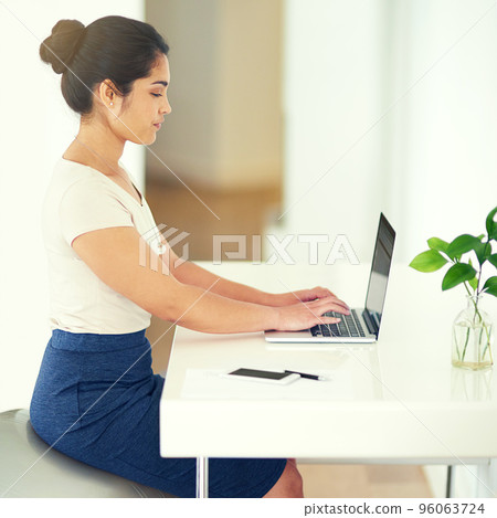 Small business, big dreams. Cropped shot of a young businesswoman working on her laptop at home. Small business, big dreams. Cropped shot of a young businesswoman working on her laptop at home. 96063724