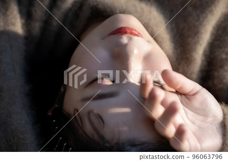 Close-up of a young woman lying in the sun 96063796
