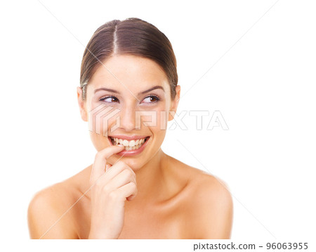 Feeling naughty. Studio shot of a beautiful young woman with perfect skin isolated on white. 96063955