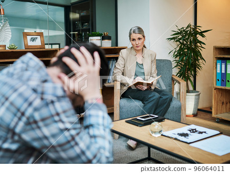 Be of service to someone whos suffering. Shot of a young man having a therapeutic session with a psychologist and looking upset. 96064011