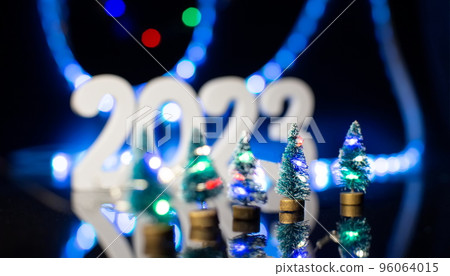 Christmas tree with decoration and lightingt 2023 , Elegant Christmas tree in glass jar with bokeh lights background, copy space. Christmas and new year concept. 96064015