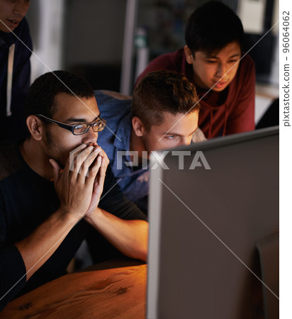 This is insane. Shot of a group of young designers staring tensely at a monitor. This is insane. Shot of a group of young designers staring tensely at a monitor. 96064062