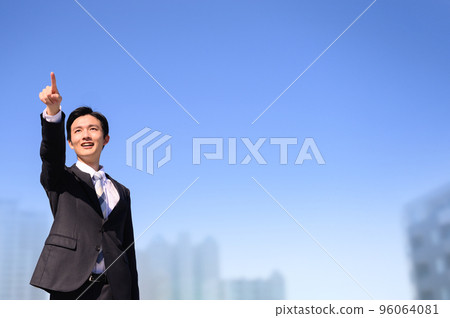 一個穿著西裝的男人用手指指著，左邊是前面的複印空間 96064081