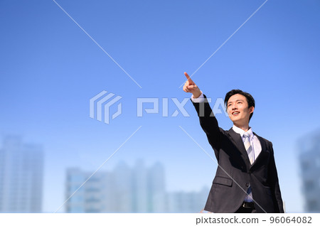 A man in a suit pointing his finger, front copy space on the right 96064082