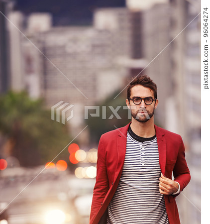 Walking the streets in style. Shot of a handsome young man taking a walk through the city. Walking the streets in style. Shot of a handsome young man taking a walk through the city. 96064274