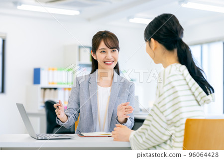 A business woman guiding a young woman A business woman guiding a young woman 96064428