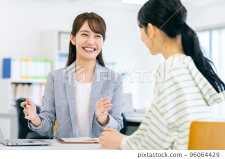 A business woman guiding a young woman A business woman guiding a young woman 96064429