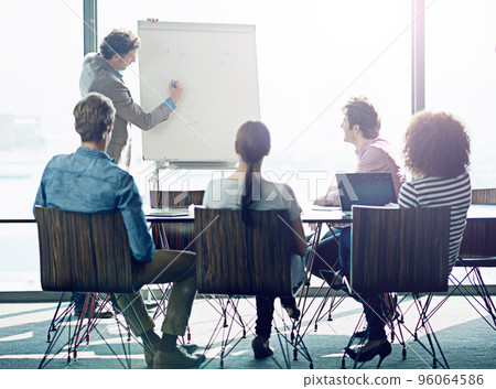Putting their ideas into action. Shot of a group of coworkers sitting in on a presentation in a boardroom. Putting their ideas into action. Shot of a group of coworkers sitting in on a presentation in a boardroom. 96064586