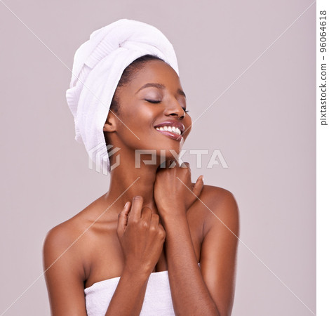 Skin that begs to be touched. An isolated studio shot of a beautiful young woman wearing a towel on her head. 96064618