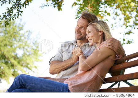 Love is inspired by the simplicity of nature. Shot of a happy mature couple sitting on a bench in the park. Love is inspired by the simplicity of nature. Shot of a happy mature couple sitting on a bench in the park. 96064904