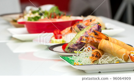 Fried Shrimps wrapped and crispy fried noodles with various food as background Fried Shrimps wrapped and crispy fried noodles with various food as background 96064909