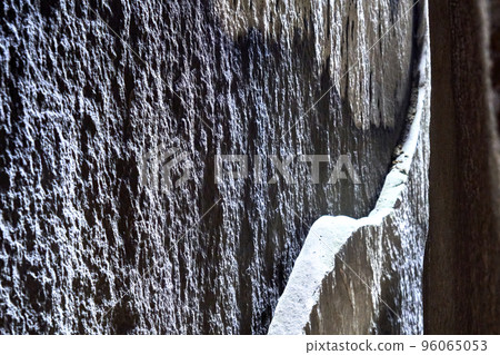 Sandstone slab on a vertical cleft surface with arched break edge, abstract graphic impression. Sandstone slab on a vertical cleft surface with arched break edge, abstract graphic impression. 96065053