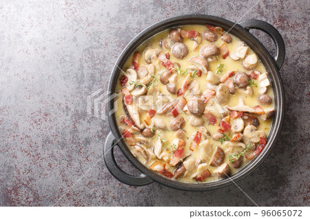 Tasty spicy mushroom and bacon sauce closeup in cast iron pan. Horizontal top view 96065072