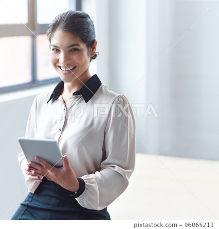 I carry my desk around with me. Portrait of a young businesswoman using a digital tablet at work. 96065211