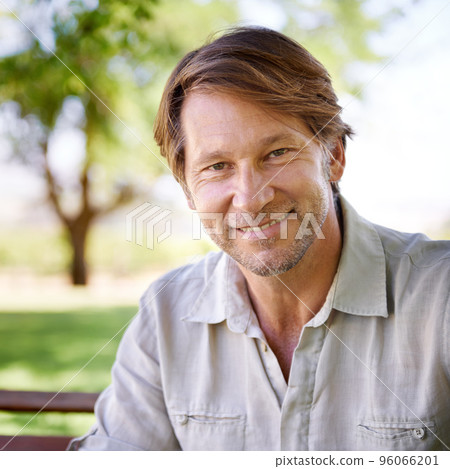 I feel most at home in the comfort of nature. Portrait of a handsome mature man enjoying a day in the park. 96066201
