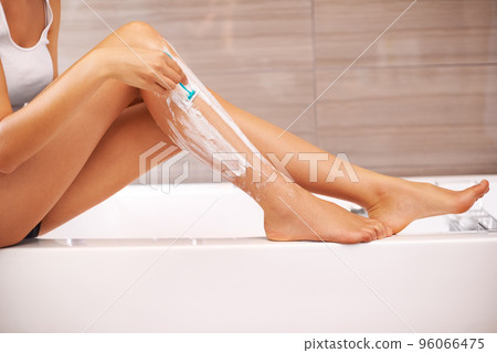 Soft and silky. Cropped view of a woman shaving her legs. 96066475