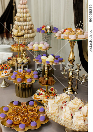 Table with cakes, sweets, candy, buffet. Dessert table for a party goodies for the wedding banquet area. Close up candy bar. Decorated delicious. 96066856