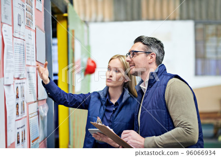 This all needs updating. Cropped shot of a two coworkers managing a warehouse. 96066934
