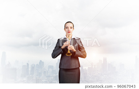Business woman playing the trumpet Business woman playing the trumpet 96067043