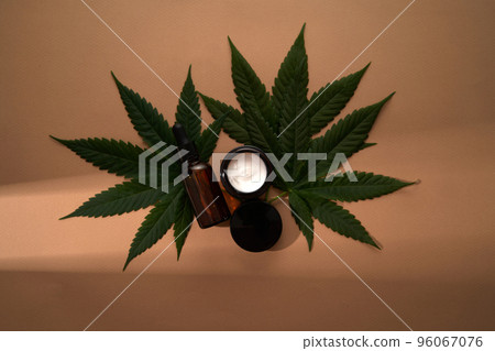 A mock-up for your face and body care cosmetic product based on medical cannabis. Serum or oil and cream on a light background. Copy space. Flat lay. Health and wellbeing concept. A mock-up for your face and body care cosmetic product based on medical cannabis. Serum or oil and cream on a light background. Copy space. Flat lay. Health and wellbeing concept. 96067076