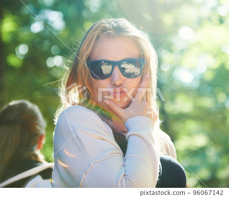 Giving you her best pout. Young woman posing with a pout while outdoors. 96067142
