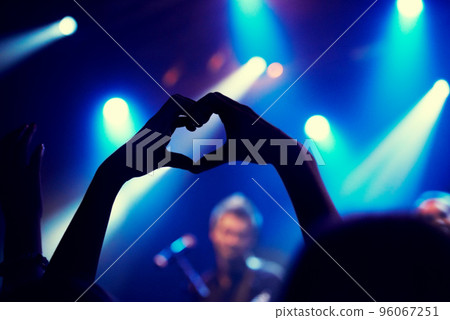 A young person showing love and light to the band on stage. This concert was created for the sole purpose of this photo shoot, featuring 300 models and 3 live bands. All people in this shoot are model 96067251