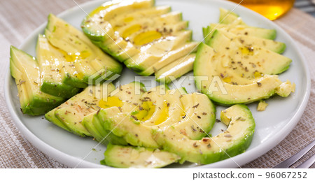 ripe avocado pulp cut into pieces sprinkled with lemon juice on a plate 96067252