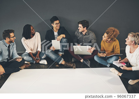 Discussing and researching ideas at the same time. Studio shot of a diverse group of creative employees having a meeting inside. 96067337