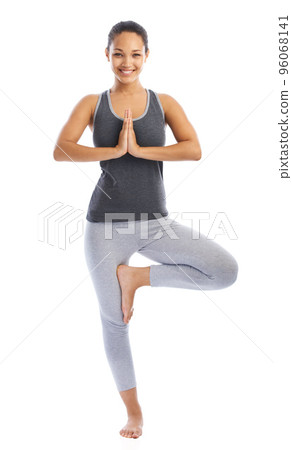 Balance and serenity. A beautiful young woman doing a yoga pose against a white background. Balance and serenity. A beautiful young woman doing a yoga pose against a white background. 96068141