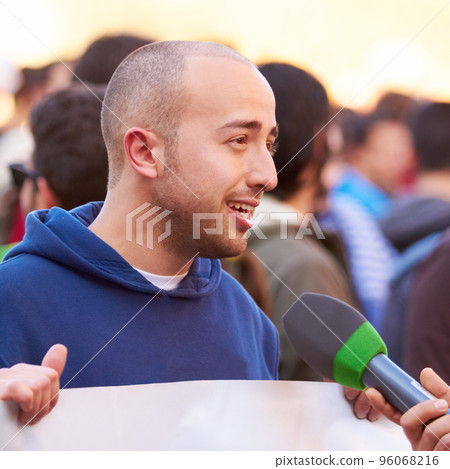 Presenting the case of the people. Shot of a protestor being interviewed at a rally. 96068216