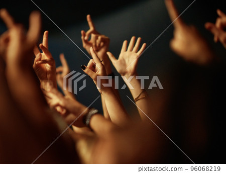Feeling the music. A crowd of people raising their arms to the music. 96068219