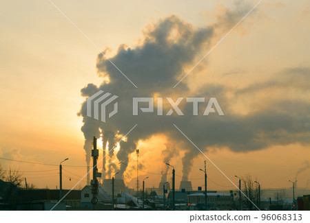 Smoke from Cogeneration rises over the city with the evening sun behind it Smoke from Cogeneration rises over the city with the evening sun behind it 96068313