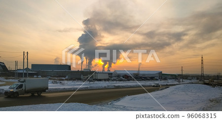 Traffic of cars on a suburban highway against the background of smoke from a thermal power plant and against the background of the evening sky at sunset 96068315