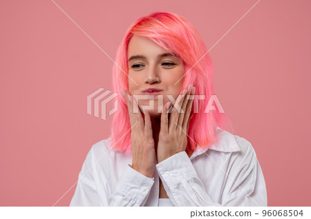 Pleased pink-haired girl touching her face while chewing 96068504