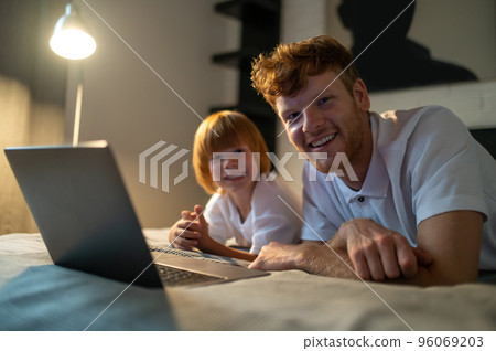 Dad and son spending time together in bed before going to sleep Dad and son spending time together in bed before going to sleep 96069203