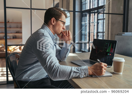 Serious crypto trader analyzing risks of buying cryptocurrency in global recession looking at chart 96069204