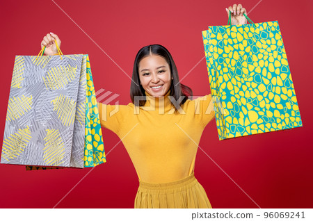 Cheerful beautiful fashionista showing off her purchases 96069241