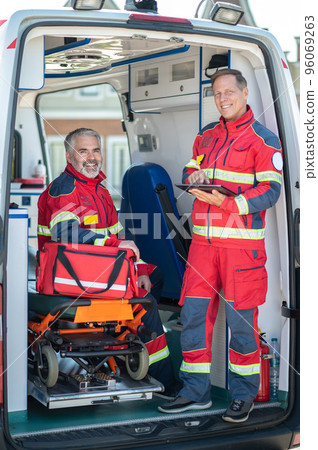 Paramedical staff posing for the camera in the EMS vehicle 96069263