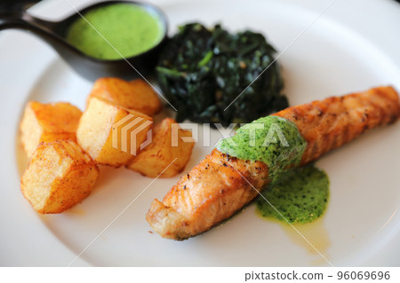 Salmon steak with pesto sauce Salmon steak with pesto sauce 96069696
